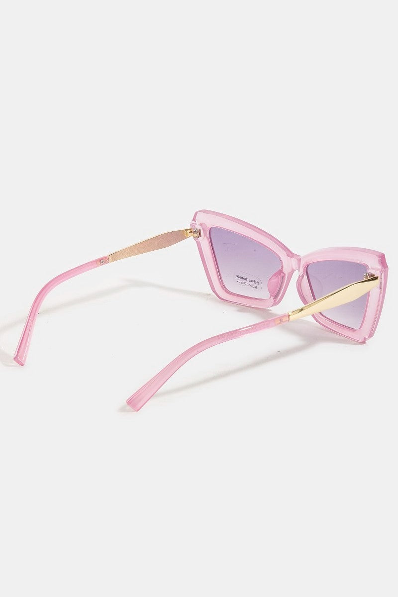 Pink cat-eye sunglasses with gold accents on a white background