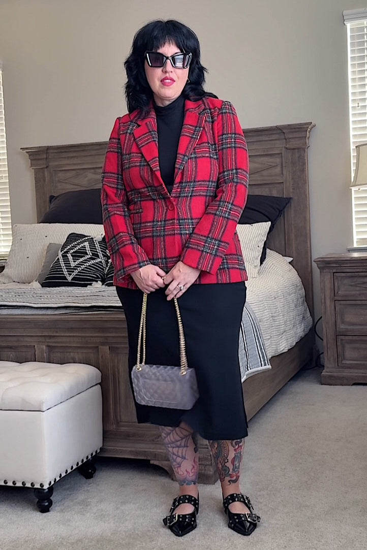 Person wearing a red plaid blazer in a bedroom setting