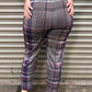 Person wearing plaid pants standing in front of a metal shutter.