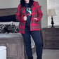 Person wearing a red plaid jacket in a bedroom setting