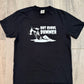 Black t-shirt with white graphic design on a wooden floor