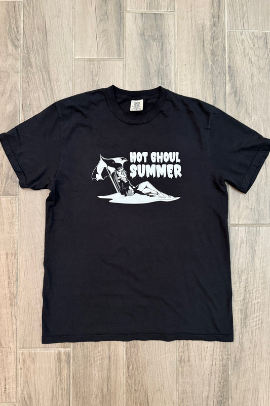 Black t-shirt with white graphic design on a wooden floor