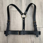 Black leather harness on a wooden floor