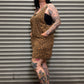 Person wearing a leopard print dress standing in front of a metal shutter.