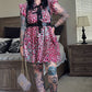 Person wearing a floral dress with suspenders in a bedroom setting