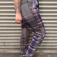 Person wearing plaid pants standing in front of a metallic shutter.