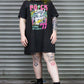 Person wearing a black graphic t-shirt and black boots in front of a metal shutter.