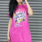 Woman wearing a bright pink t-shirt with graphic design against a metallic shutter background