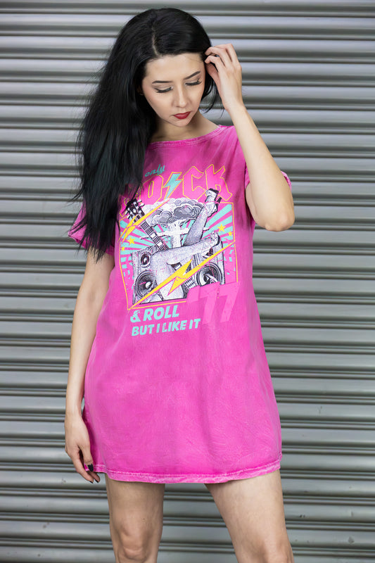 Woman wearing a bright pink t-shirt with graphic design against a metallic shutter background
