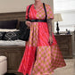 Person wearing a pink and gold checkered dress in a bedroom setting