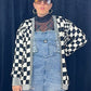 woman in sunglasses wearing overalls and black and white checkered cardigan