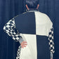 back of a woman wearing a black and white checkered cardigan