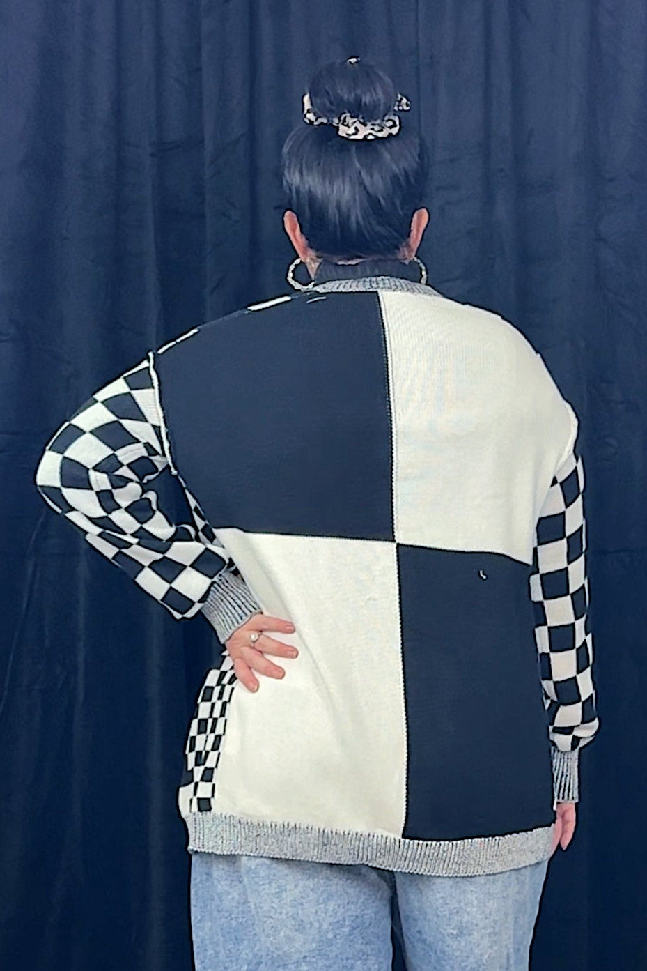 back of a woman wearing a black and white checkered cardigan