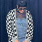woman in sunglasses wearing overalls and black and white checkered cardigan