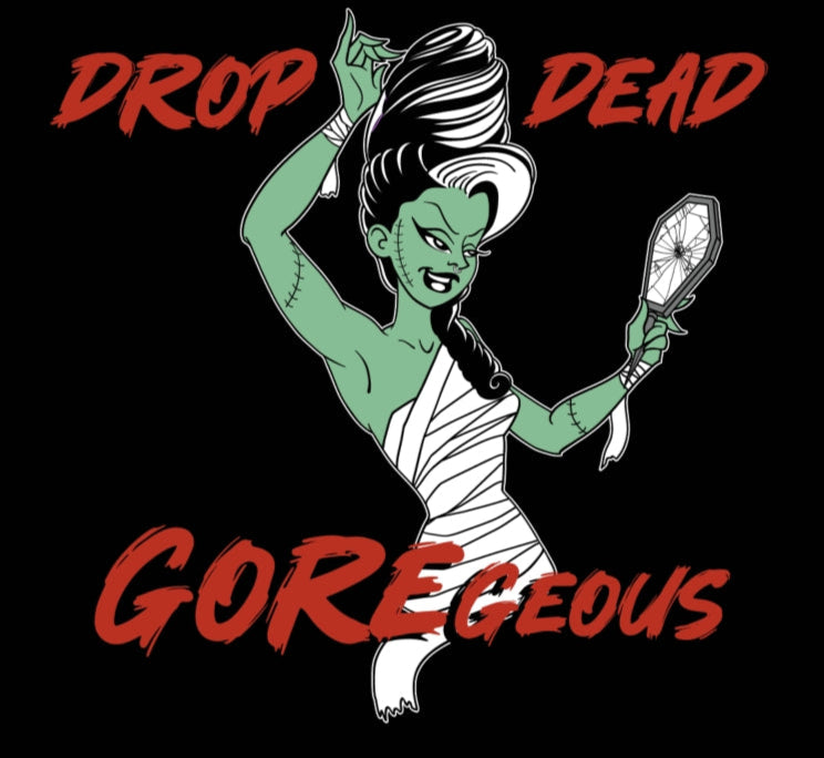 Illustration of a green-skinned woman with white hair, holding a mirror, with text 'Drop Dead Gorgeous' on a black background.