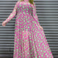 Person wearing a pink dress with green and pink leopard print against a metallic shutter background