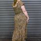 Woman wearing a patterned dress standing in front of a metal shutter.