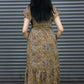 Woman wearing a patterned dress standing in front of a metallic shutter.