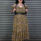 Woman wearing a leopard print dress with tattoos standing in front of a metal shutter.