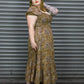Woman wearing a patterned dress standing in front of a metal shutter.