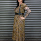 Woman in a patterned dress standing in front of a metal shutter.