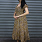 Woman wearing a patterned dress standing in front of a metal shutter.