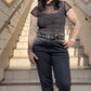 Person with tattoos standing on a staircase with a clear blue sky in the background
