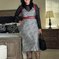 Woman in a sequined dress standing in a bedroom