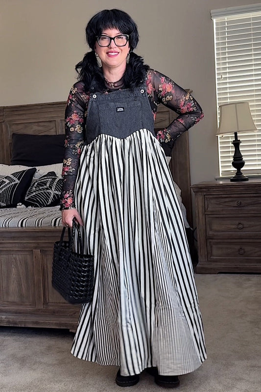 Woman in a striped dress standing in a bedroom