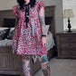 Woman in a leopard dress standing in a bedroom