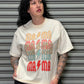 Person wearing a white t-shirt with colorful text design against a metallic shutter background
