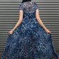 Woman wearing a blue leopard print dress standing in front of a metallic shutter.