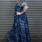 Woman wearing a blue leopard print dress standing against a metallic shutter.