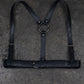 Black leather harness on a textured gray surface
