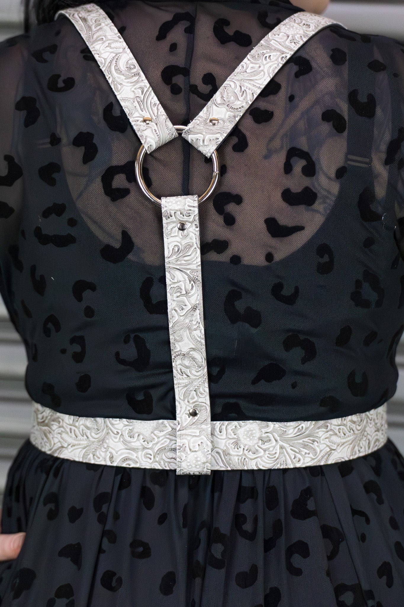 Black dress with a leopard print pattern and a white harness.