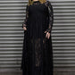 Person wearing a long maxi lace dress against a metal shutter background.