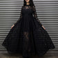 Woman wearing a black lace dress standing in front of a metal shutter.