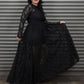 Woman wearing a black lace dress against a metallic background