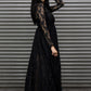 Woman wearing a black lace dress standing against a metallic shutter.