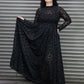 Woman wearing a black mesh leopard dress standing against a metal shutter.