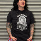 Person wearing a black t-shirt with a graphic design standing in front of a metallic shutter.