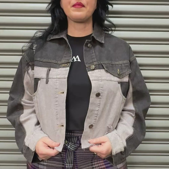 Women modeling split black and white denim jacket.