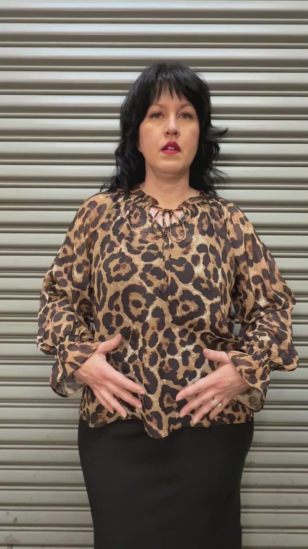 Women modeling leopard print top.