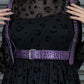 Black dress with purple leopard print and a purple harness worn by a person.