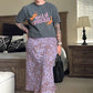 A person wearing a gray t-shirt with the text 'Wild Woman' and a midi-length A-line skirt with a lavender leopard print. Accessories include black strappy sandals and a black bag.