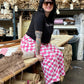 Person in a storage room with shelves filled with rolls of paper or fabric.