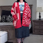 Person wearing a red checkered cardigan over a graphic t-shirt in a living room.