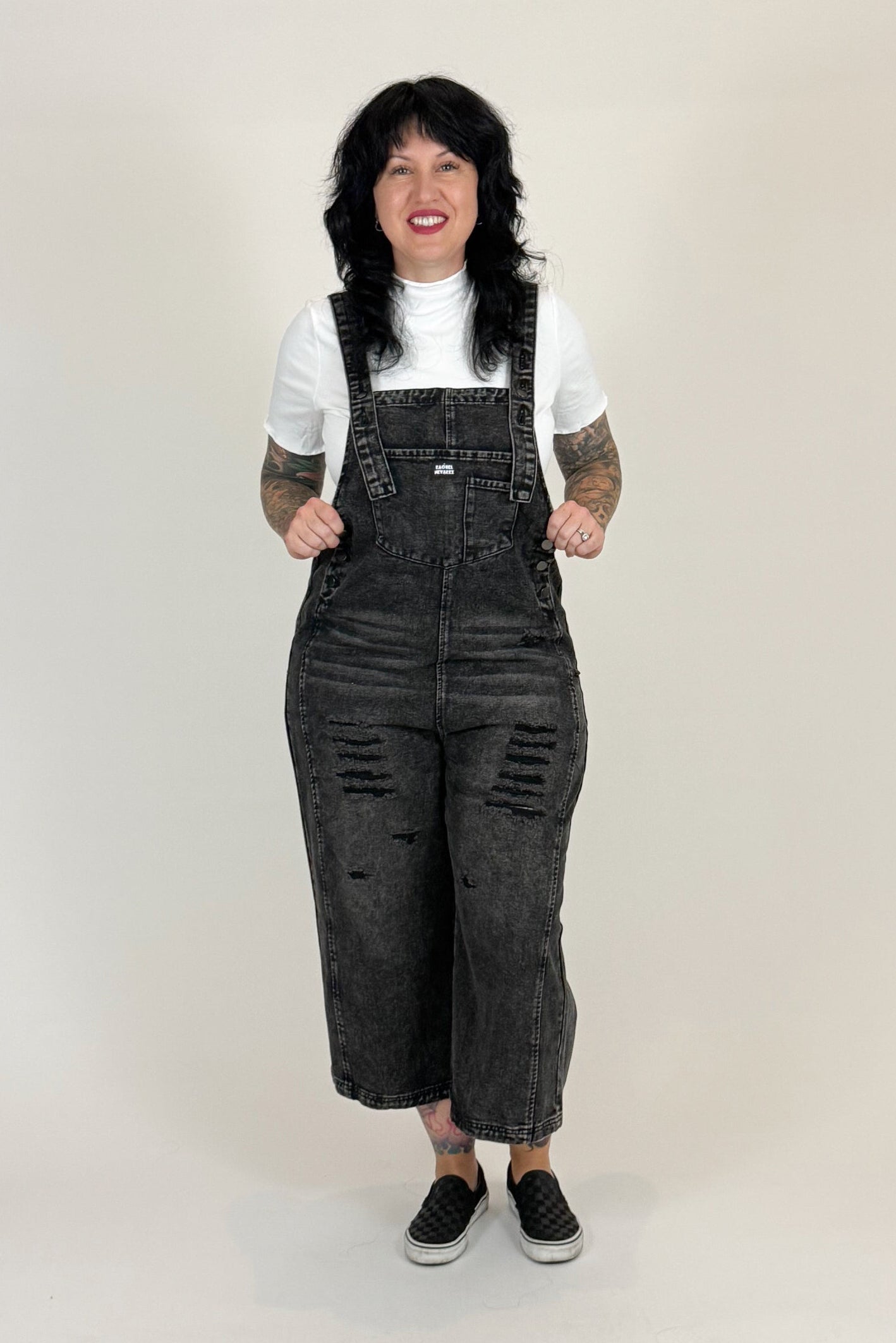 women wearing black distressed overalls