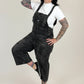 Woman wearing black overalls and a white shirt on a white background