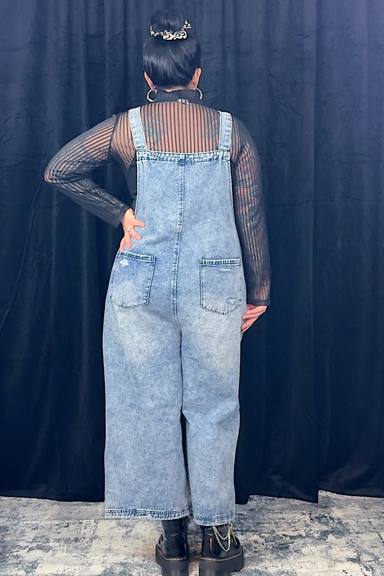 women in striped top wearing light blue overalls